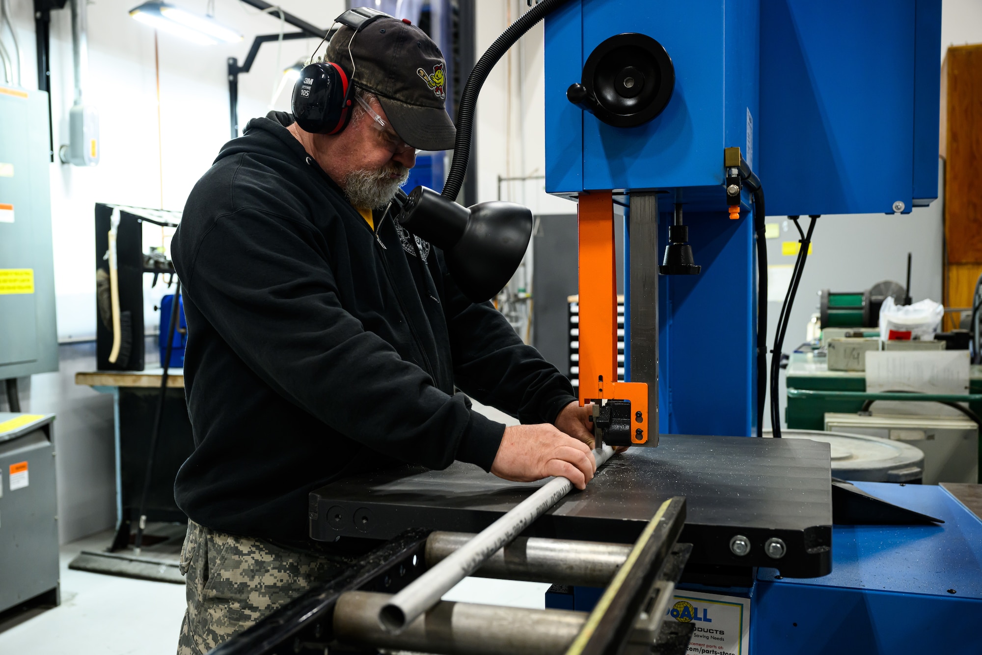 A man cuts a length of pipe
