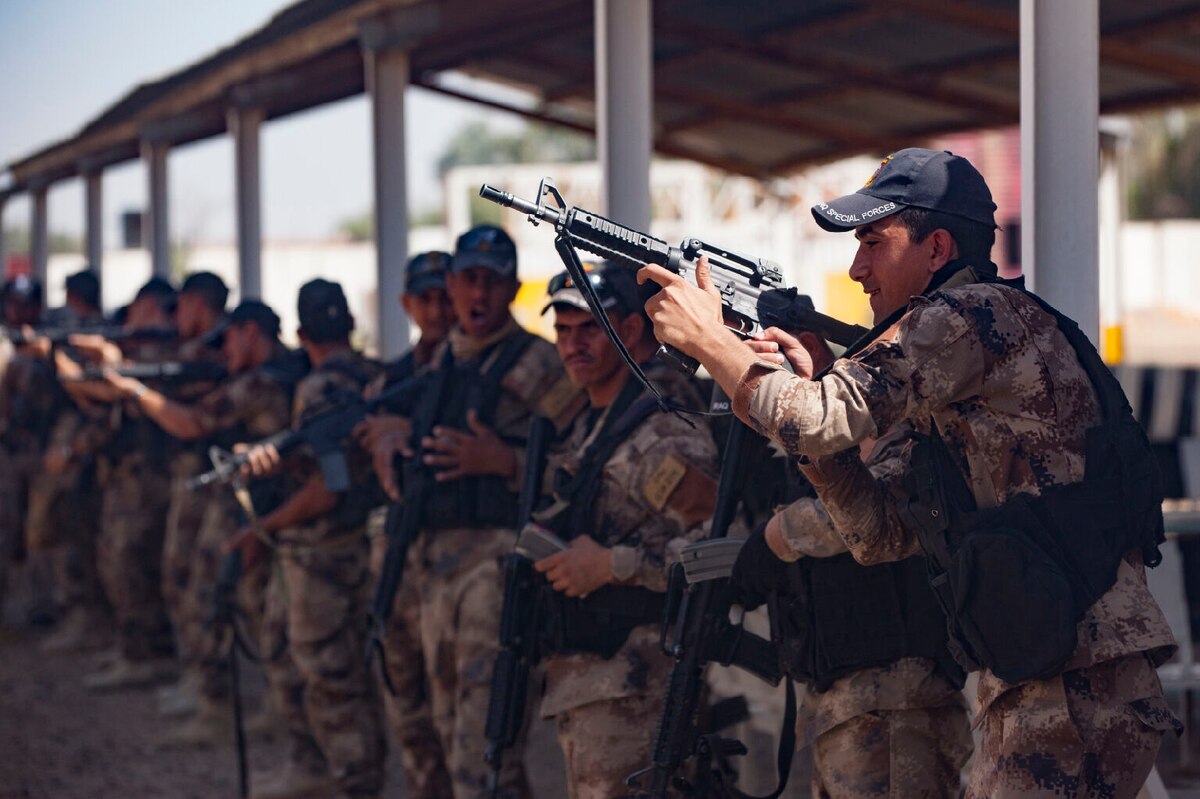 Iraqi soldiers reload their rifles at a firing point.