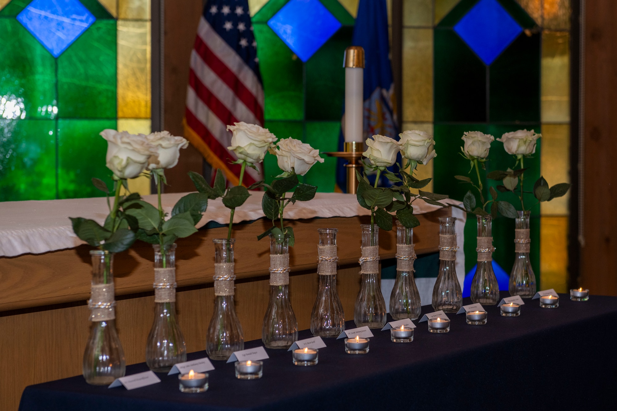 White roses and tealight candles are displayed representing the fallen