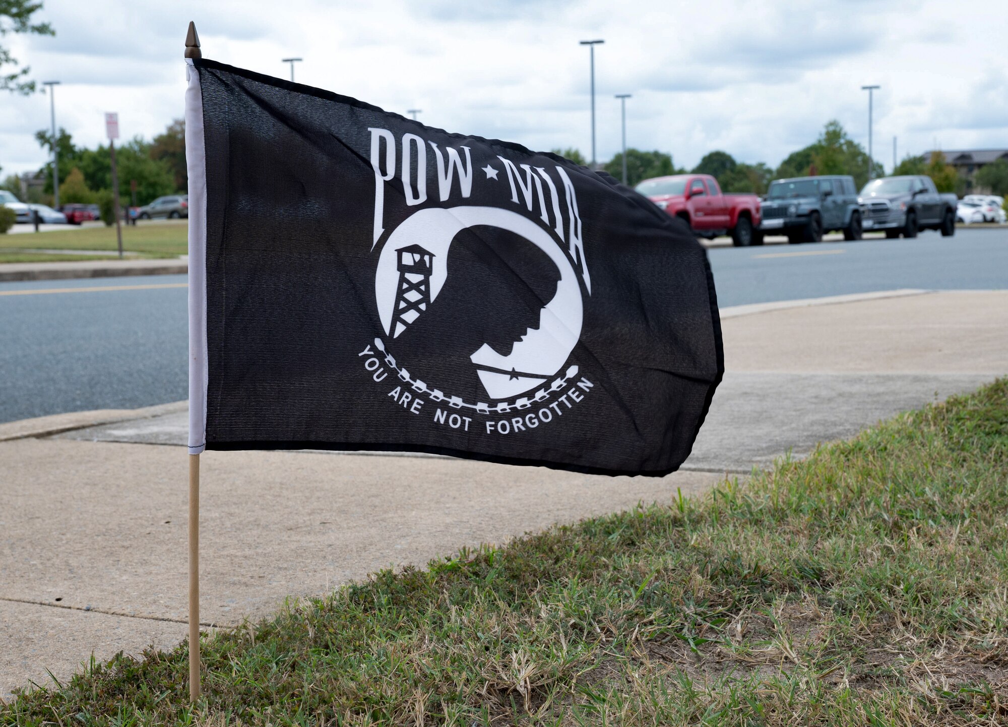 A POW/MIA flag flies as one of many on the rucking path for POW/MIA Recognition Day at Dover Air Force Base, Delaware, Sept. 26, 2024. In recognition of POW/MIA, Team Dover held a 24-hour ruck that was followed by a closing retreat ceremony, honoring all military personnel who have been taken captive and returned, as well as those who remain missing. (U.S. Air Force photo by Airman Liberty Matthews)