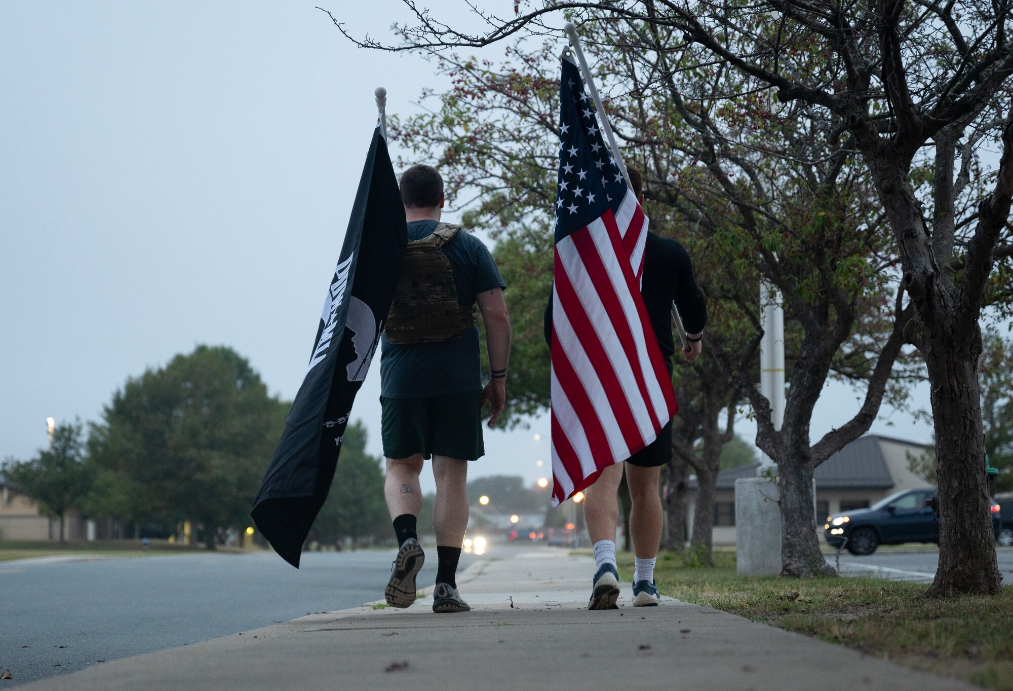 Two participants run holding the POW/MIA flag and the U.S. flag in the POW/MIA Recognition Day ruck at Dover Air Force Base, Delaware, Sept. 27, 2024. In recognition of POW/MIA, Team Dover held a 24-hour ruck that was followed by a closing retreat ceremony, honoring all military personnel who have been taken captive and returned, as well as those who remain missing. (U.S. Air Force photo by Airman Liberty Matthews)