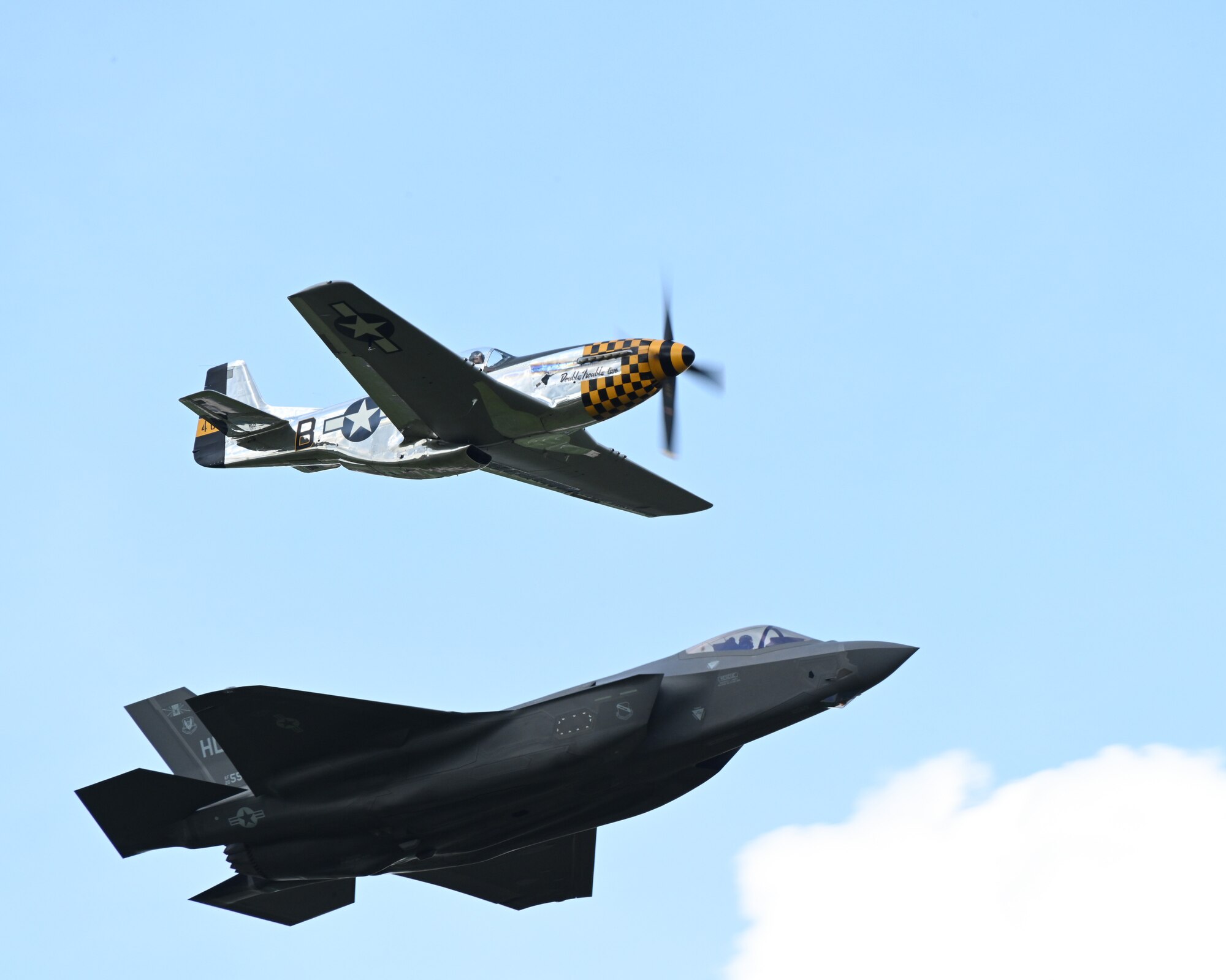 F-35 Lightning II and a P-51 Mustang fly together.