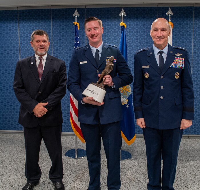 Capt. Harry “Butcher” McMahon holds the 2024 Kolligian Trophy, flanked by Air Force Chief of Staff Gen. David Allvin and Mr. Kyle Anderson, at the Pentagon, Arlington, Va., Sept. 26, 2024. The Koren Kolligian Jr. Trophy recognizes outstanding feats of airmanship by aircrew members who by extraordinary skill, exceptional alertness, ingenuity, or proficiency, averted accidents or minimized the seriousness of the accidents in terms of injury, loss of life, aircraft damage or property damage. (U.S. Air Force photo)
