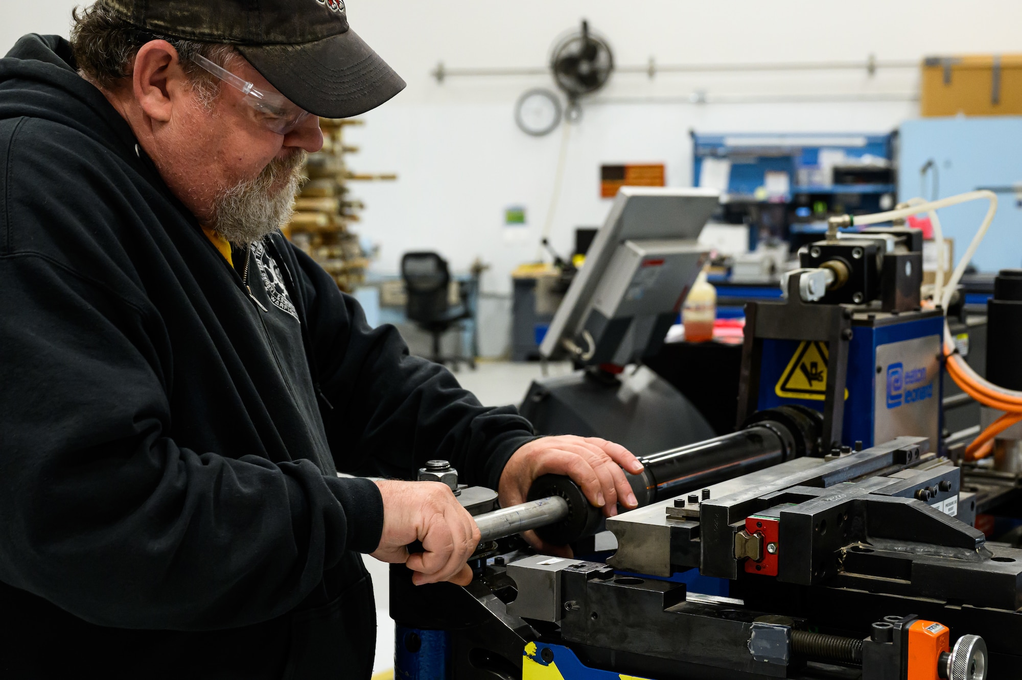 A man uses a pipe bending machine