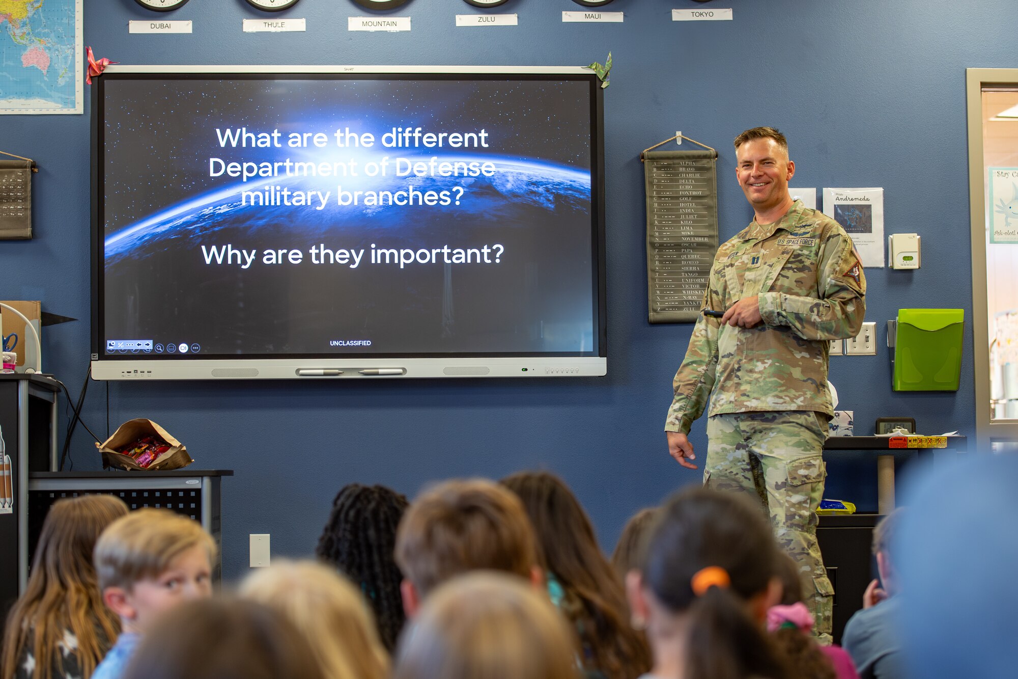 Military member in uniform briefs classroom of fifth grade students