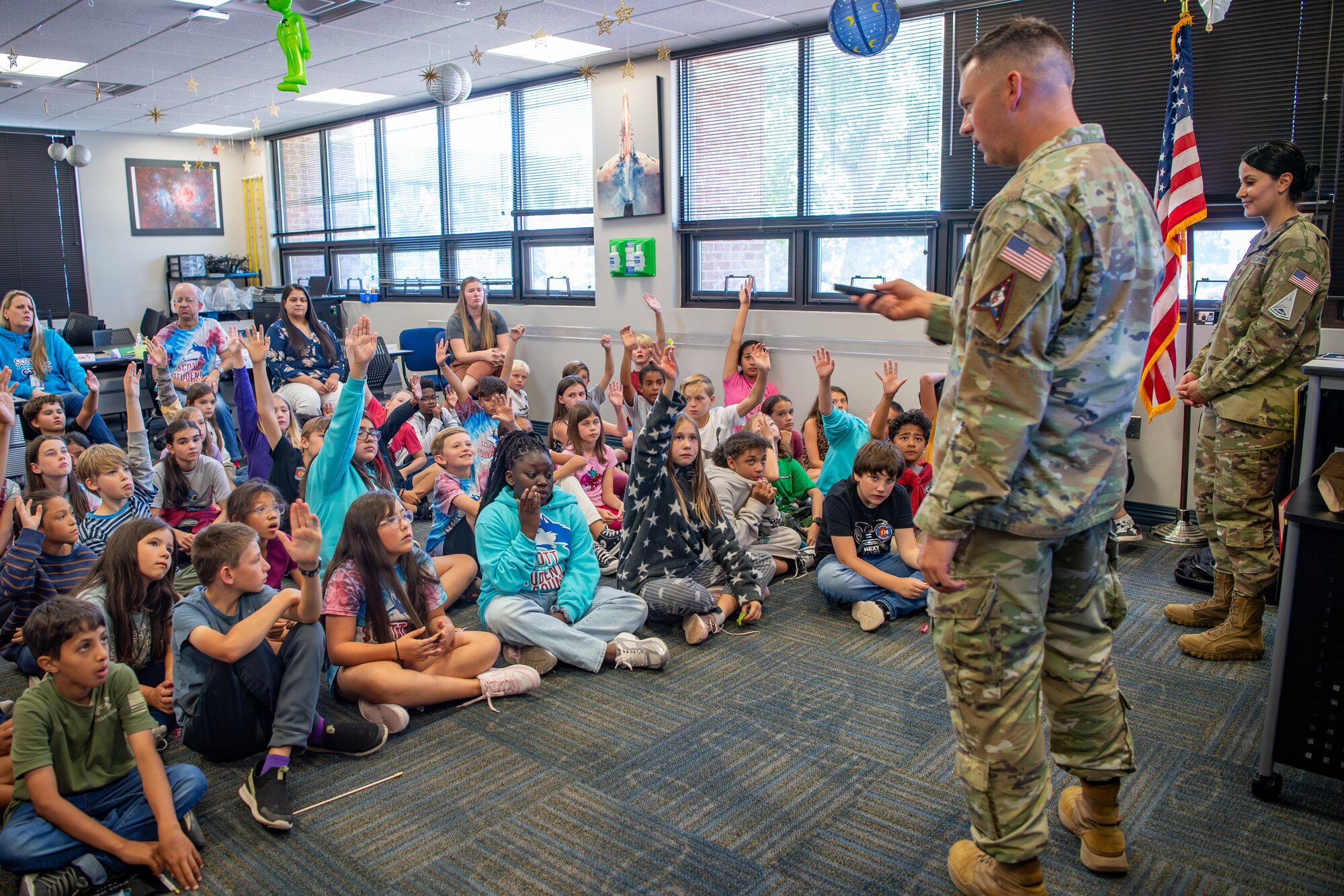 Two servicemembers brief classroom of fifth grade students