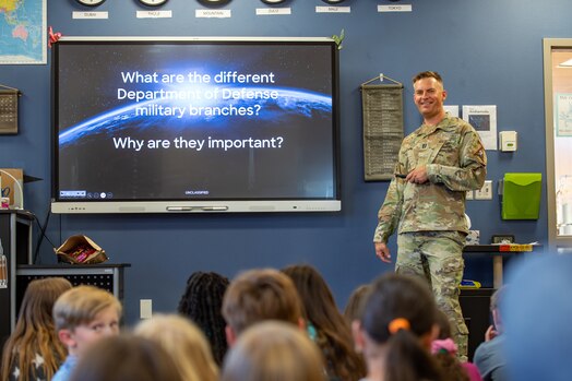  Military member in uniform briefs classroom of fifth grade students
