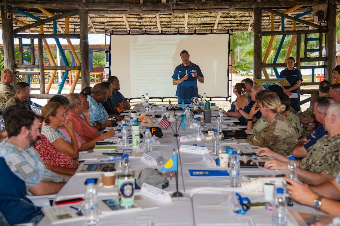 240916-N-ML137-1096 PELELIU, Republic of Palau (Sept. 16, 2024) - U.S. Coast Guard Lt. Cmdr. Derek Wallin, marine advisor with U.S. Coast Guard Forces Micronesia/Sector Guam, gives a presentation during the biannual, bilateral Joint Committee Meeting at South Dock Summerhouse, Sept. 16. JCMs are aligned with the Compact of Free Association Title III: Security and Defense Relations, enabling ongoing dialogue between nations to enhance security and defense responsibilities in the region. This meeting underscores the mutual commitment to national security, international partnership, and environmental stewardship in the Pacific. (U.S. Navy photo by Mass Communication Specialist 1st Class Samantha Jetzer)