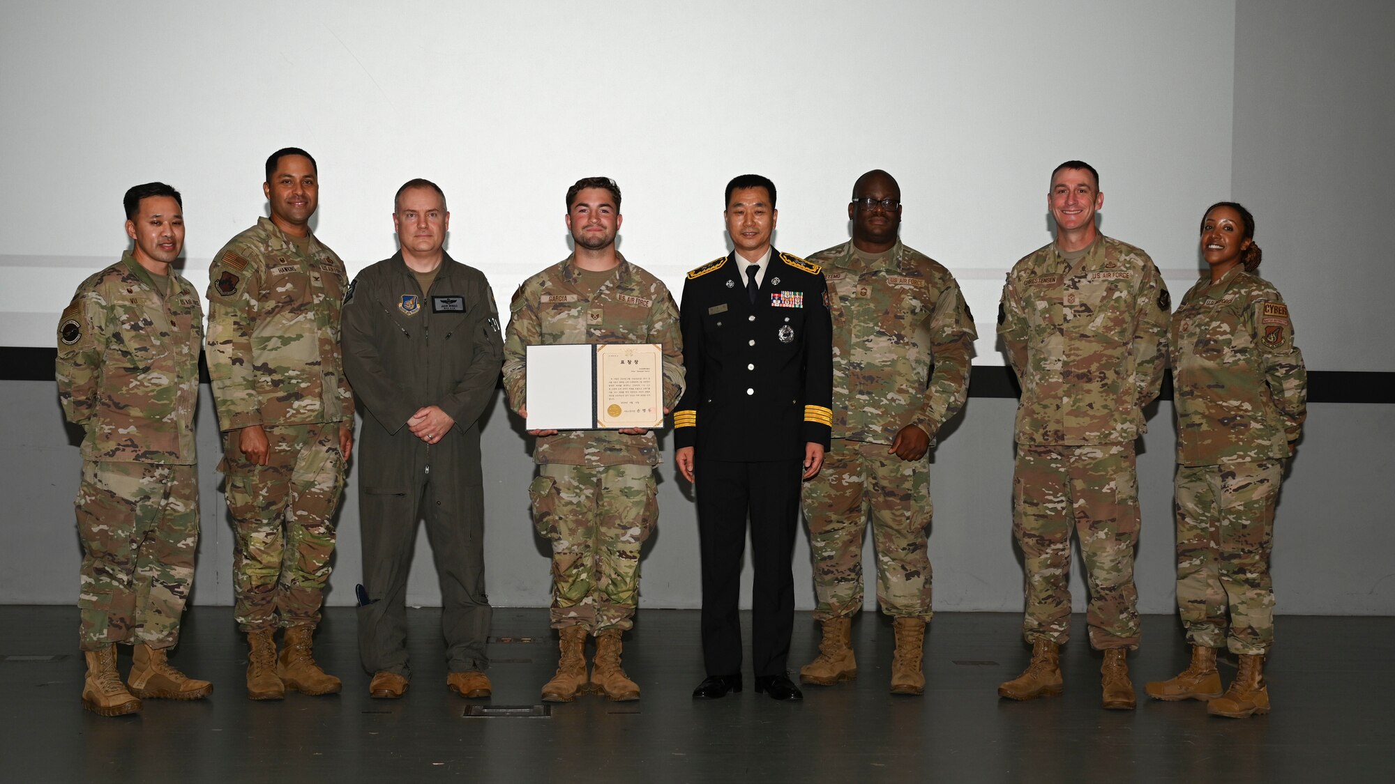 U.S. Air Force Staff Sgt. Natanael Garcia, center left, 8th Communications Squadron network system operations supervisor, stands with Yi, Jong-jun, center right, Seoul Fire Department duty director, and base leadership during a recognition ceremony at Kunsan Air Base, Republic of Korea.