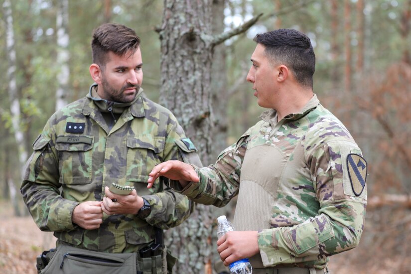 U.S. Army 2nd Lt. Austin Yoakum (right), a fire support officer assigned to Bravo “Eager” Battery, 2nd Battalion, 8th Cavalry Regiment, 1st Armored Brigade Combat Team, 1st Cavalry Division, explains calls for fire procedures to Czech army Sgt. Tomas Kodad (left), a forward observer assigned to the 13th Artillery Regiment, during exercise Flaming Thunder at Camp Taurus, Lithuania, Sept. 25, 2024. Exercise Flaming Thunder was a multinational exercise utilizing the Lithuanian Joint Air Ground Integration Cell. The 1st Cavalry Division’s mission is to engage in multinational training and exercises across the continent, strengthening interoperability with NATO allies and regional security partners, which provides competent and ready forces to V Corps, America’s forward-deployed corps in Europe. (U.S. Army photo by Capt. Zackery Babcock)