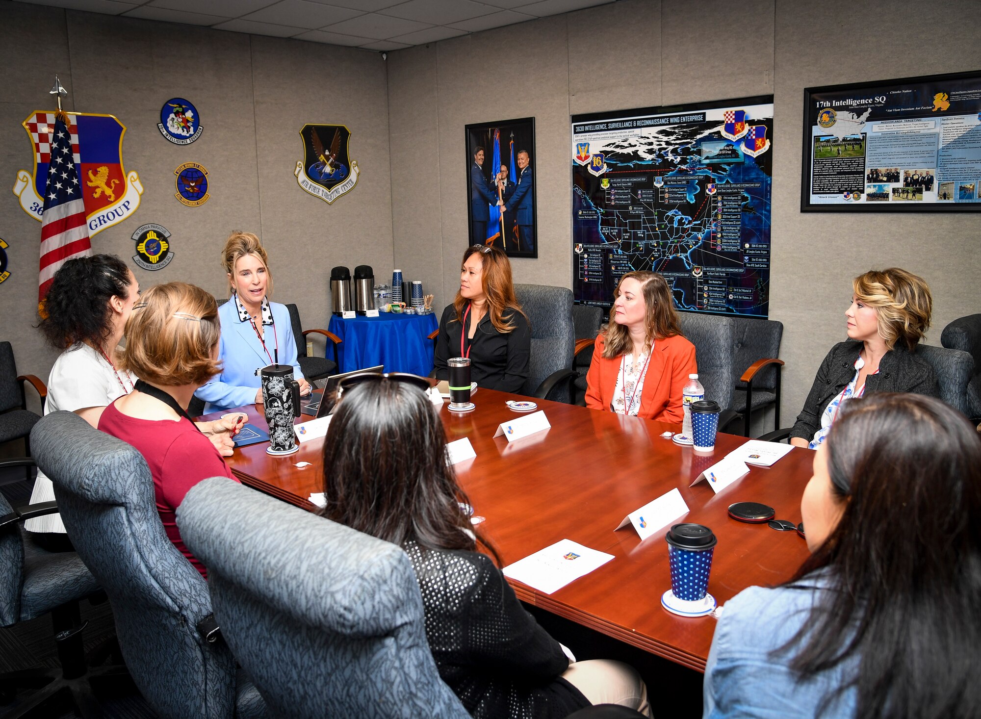 A group of spouses chat at a table.