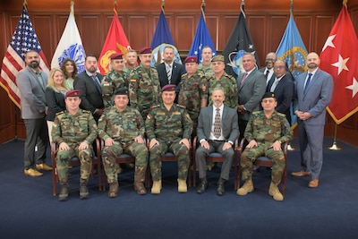 A group of men and women sit in chair or behind them