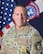 Male Soldier in front of United States and Army Recruiting Brigade flags