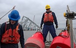 Petty Officer 1st Class Anthony Tartaglia, a machinery technician from U.S. Coast Guard Sector Maryland - National Capital Region, assists with the deployment of federal aids to navigation marking the Fort Carroll Temporary Alternate Channel on April 19, 2024. The Key Bridge Response is one of the operational missions that will qualify for special leave accrual (SLA) in FY 24.
