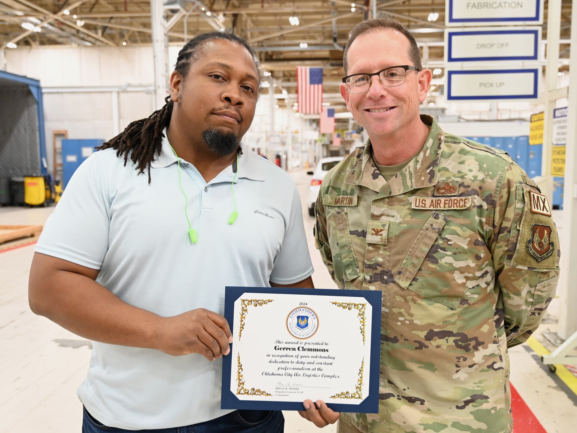 Two men holding award certificate.
