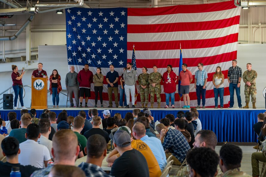 U.S. Air Force Col. James Schlabach, 91st Missile Wing commander (left), highlights organizations at Team Minot that foster resiliency during an All Call at Minot Air Force Base, North Dakota, Sept. 27, 2024. This event was part of a day focused on suicide prevention and resiliency. (U.S. Air Force photo by Airman 1st Class Luis Gomez)