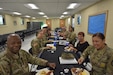 Soldiers in Army uniform and Army Civilian employees have a conversation over a pancake breakfast