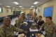 Soldiers in Army uniform and Army Civilian employees have a conversation over a pancake breakfast