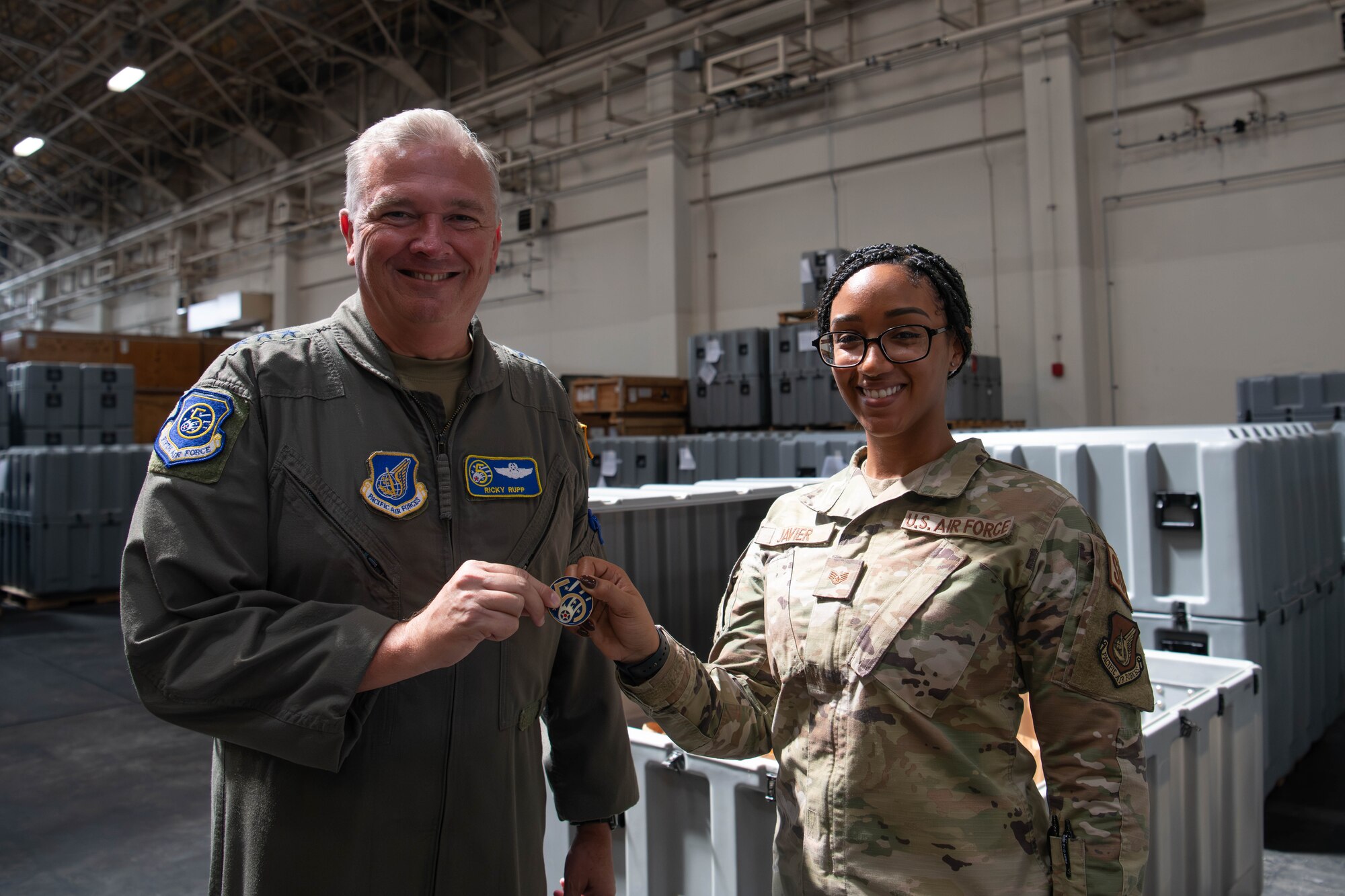 U.S. Air Force Lt. Gen. Ricky Rupp, U.S. Forces Japan and 5th Air Force commander, poses for a photo after coining Staff Sgt. Ariana Javier, 374th Logistics Readiness Squadron war reserve materiel NCO in charge.