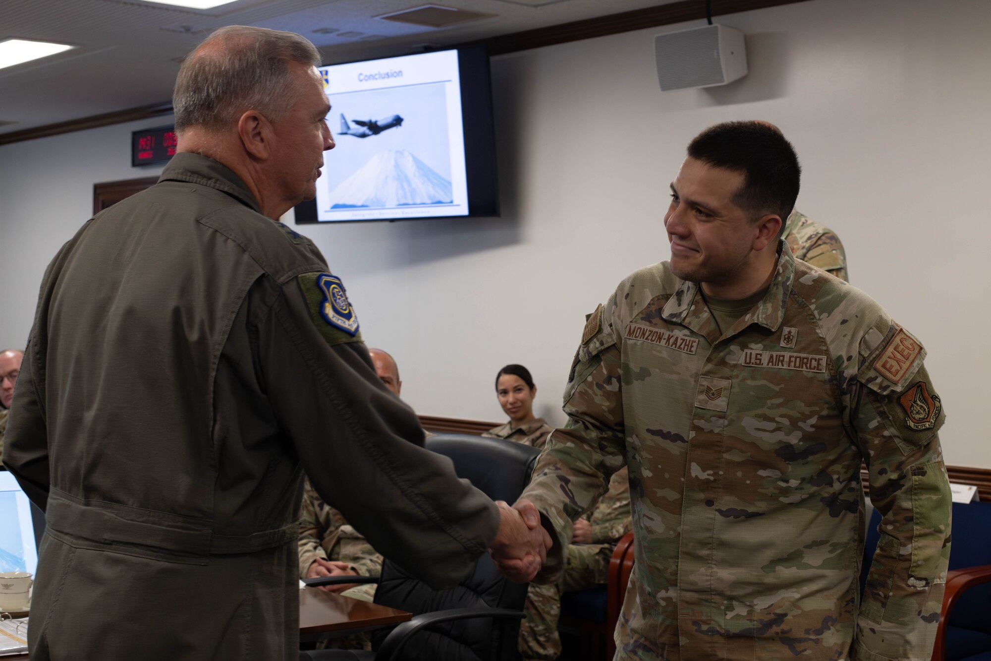 U.S. Air Force Lt. Gen. Ricky Rupp, U.S. Forces Japan and 5th Air Force commander, coins Tech. Sgt. Daniel Monzon-Kazhe, 374th Airlift Wing commander executive, during a base staff tour.
