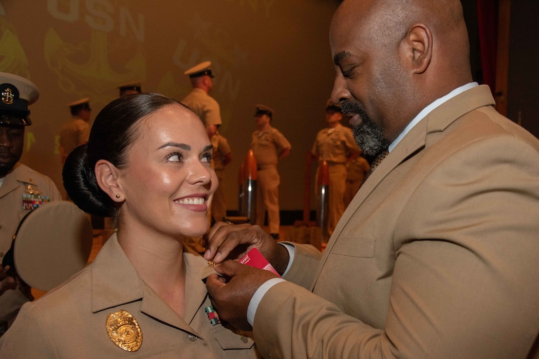 Chief Master-at-Arms Natalie Hasbrouck, assigned to Commander, Fleet Activities Yokosuka (CFAY), receives fouled anchor pins during the Chief Pinning Ceremony held at the installation’s Fleet Theater. Hasbrouck was one of the 14 new chiefs with the command pinned with the new rank.