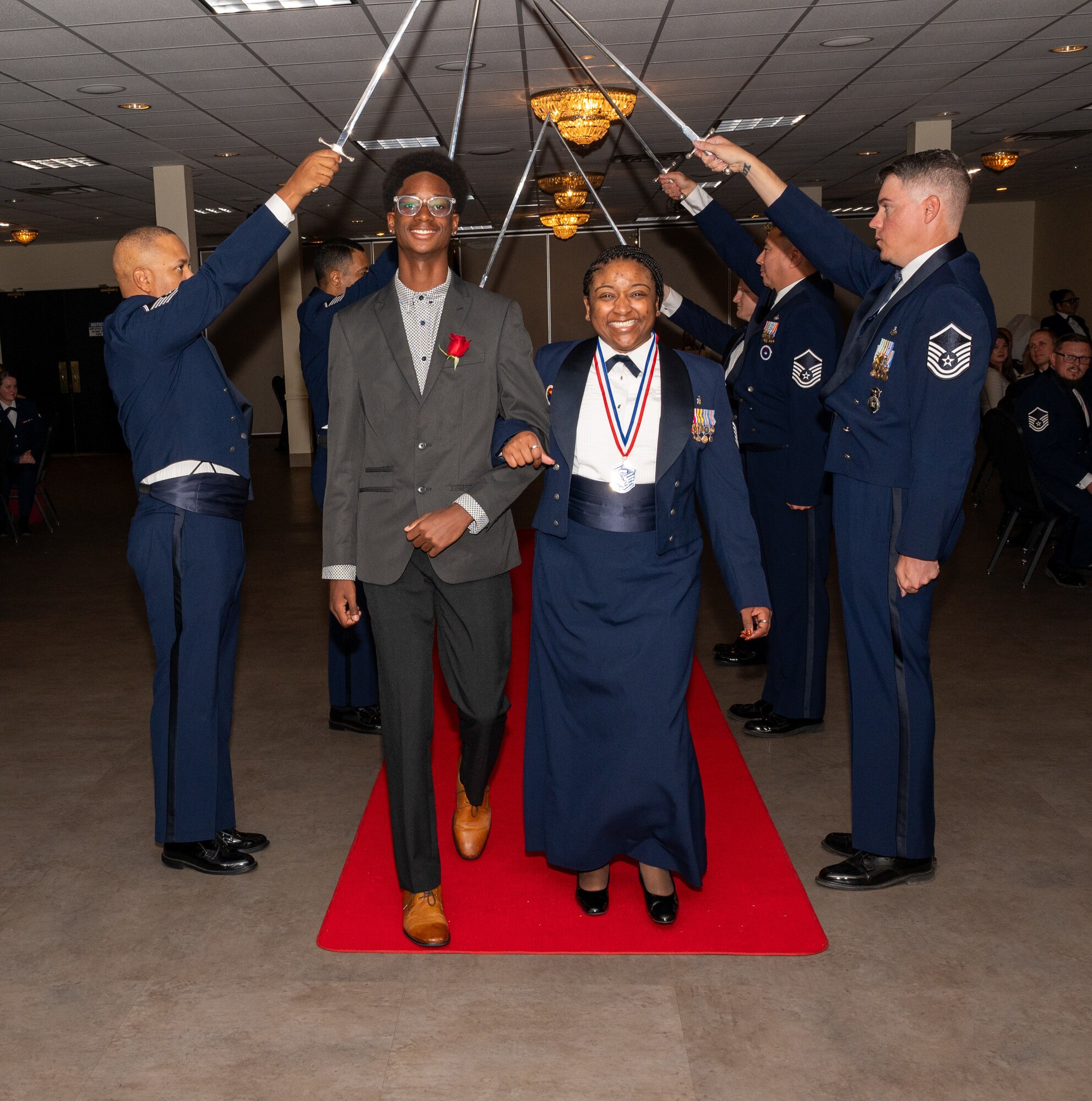 U.S. Air Force (M)Sgt Janelle Ramsey, 47th Medical Group, walks under the Saber Team's swords during the senior non-commissioned officer induction ceremony at Laughlin Air Force Base, Texas, Sept. 27, 2024. The induction ceremony brings Airmen together to celebrate the achievement of entering the realm of senior enlisted leaders. (U.S. Air Force photo by Staff Sgt. Nicholas Larsen)