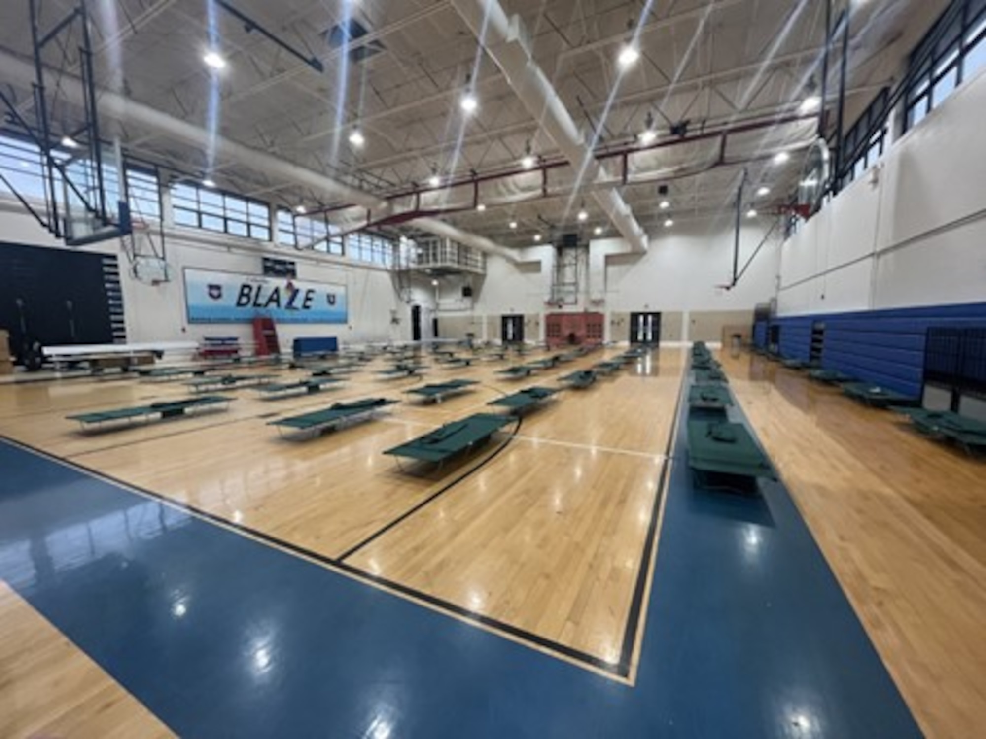 Cots laid out on CAFB gym floor.