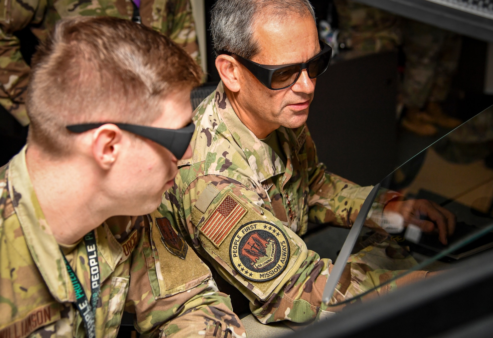 Two individuals look at a screen with special glasses.