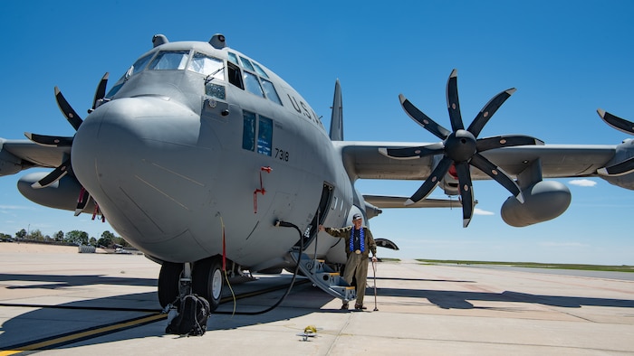 A man stands next to a C-130 aircraft.