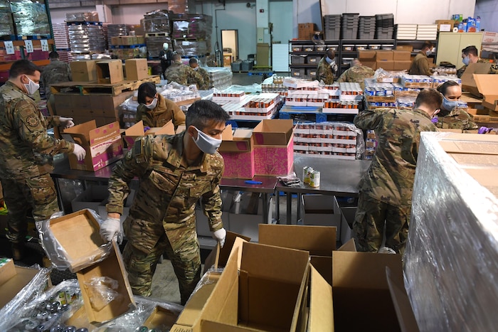 Soldiers and Airmen from the Washington National Guard pack food boxes at the Nourish Food Bank warehouse April 3, 2020 in Lakewood, WA.
