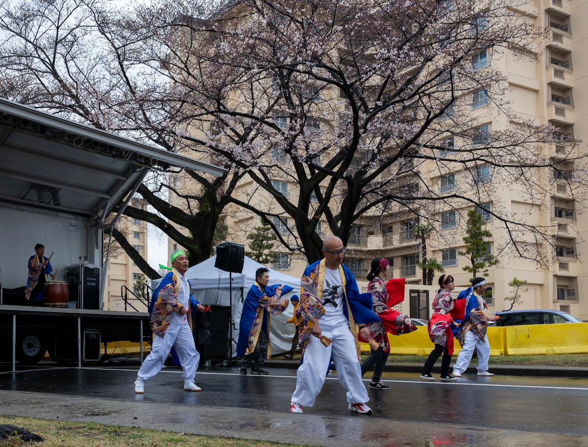 Japanese dancers perform in front of a stage.
