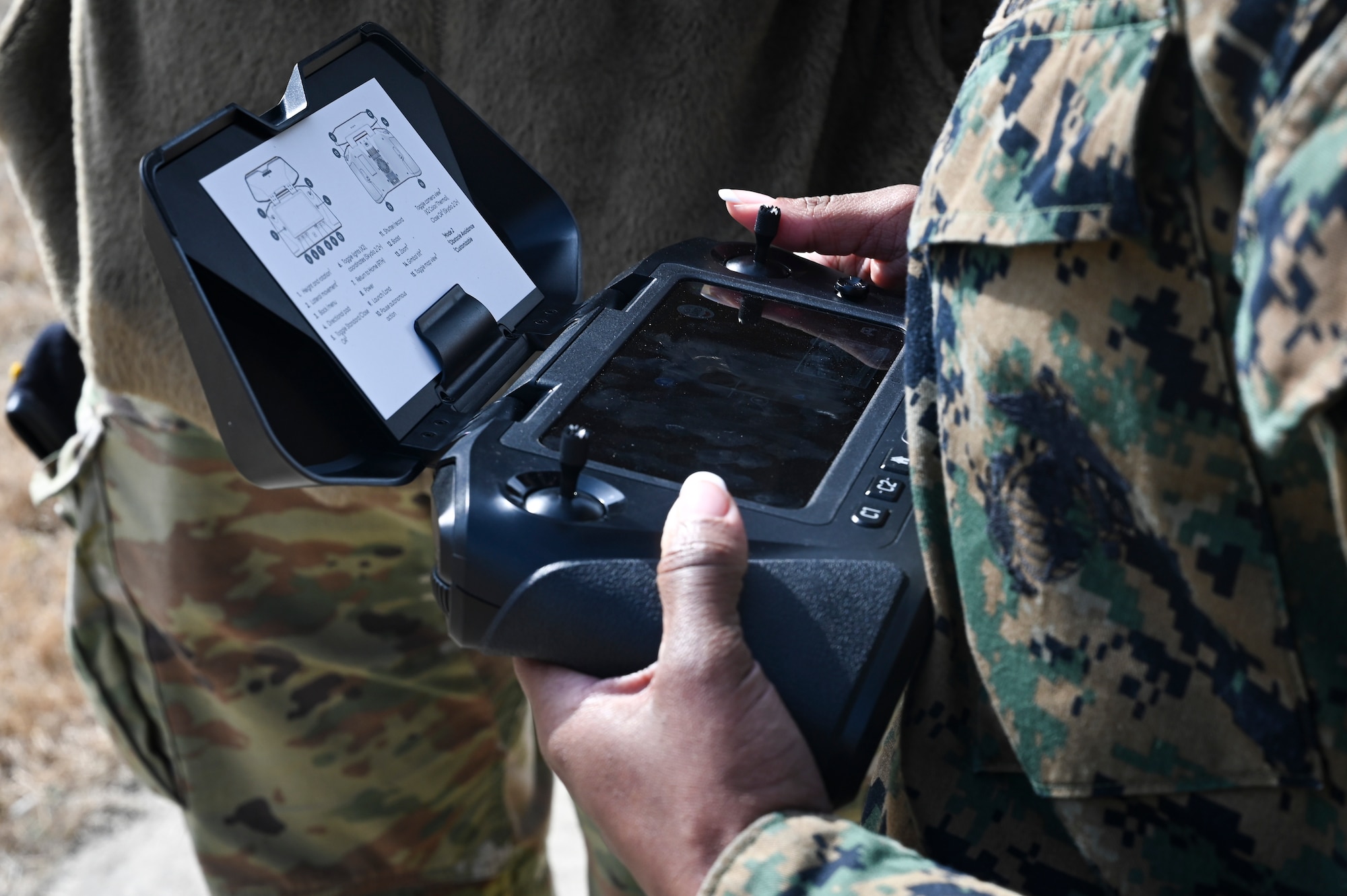 U.S. Marine Corps Sgt. Cyan Williams, an electrician with Marine Wing Support Squadron 172, Marine Aircraft Group 36, 1st Marine Aircraft Wing, learns to control a small unmanned aircraft system.