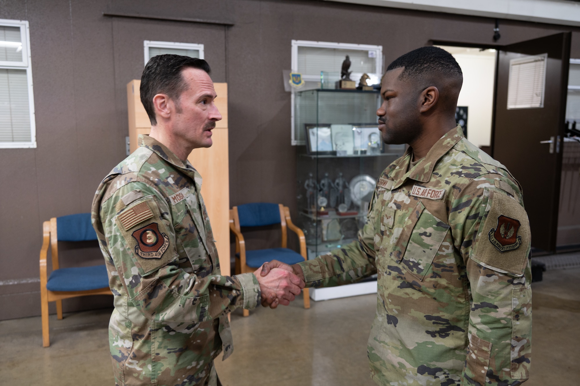 U.S. Air Force Maj. Gen. Paul Moga, Third Air Force commander, coins Airman 1st Class Tavarrio Brown