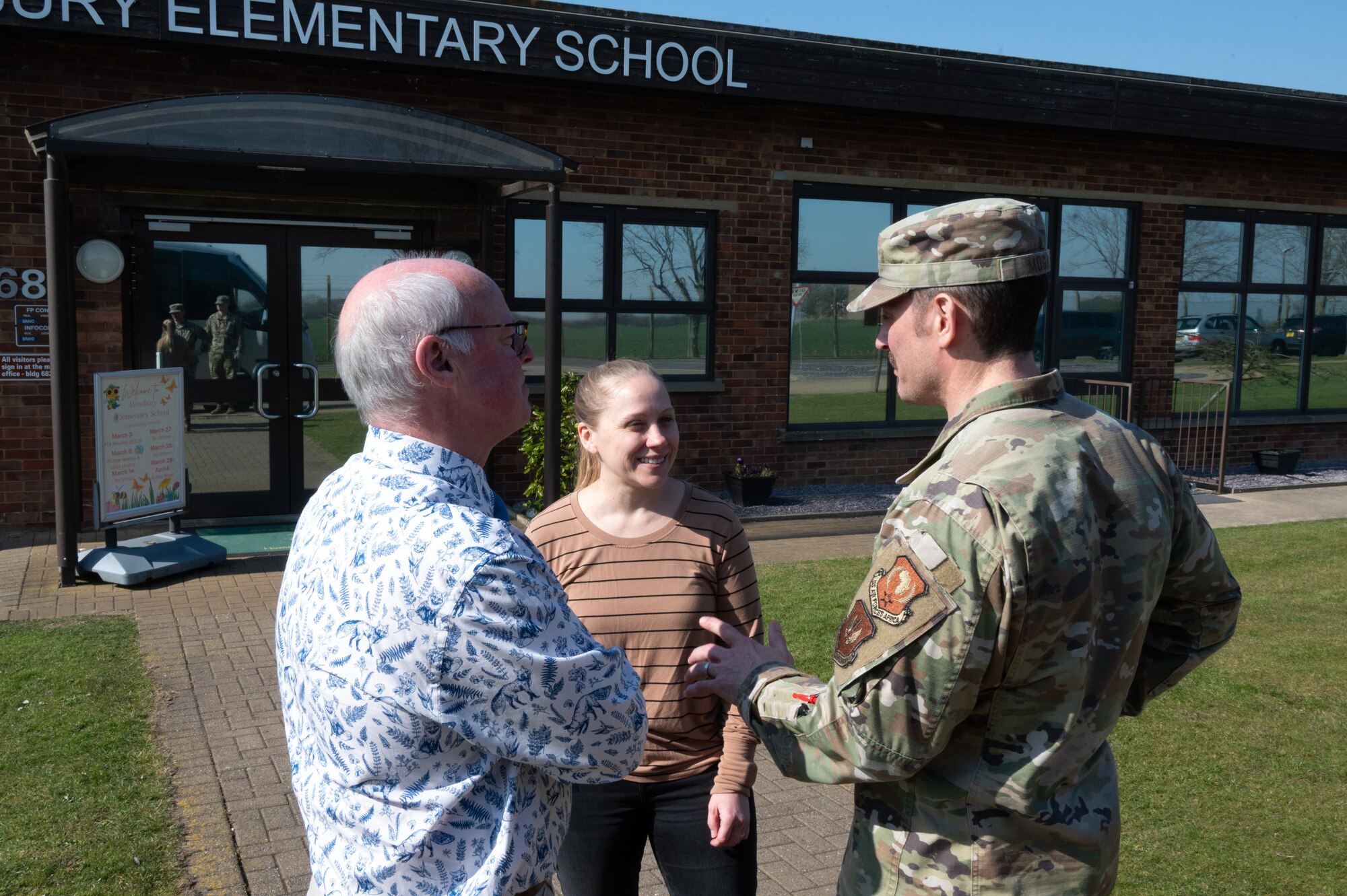 U.S. Air Force Maj. Gen. Paul Moga, Third Air Force commander, speaks with elementary school staff members