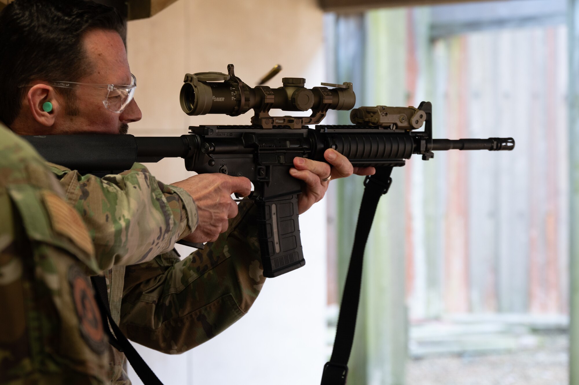 U.S. Air Force Maj. Gen. Paul Moga, Third Air Force commander, fires an M4 rifle