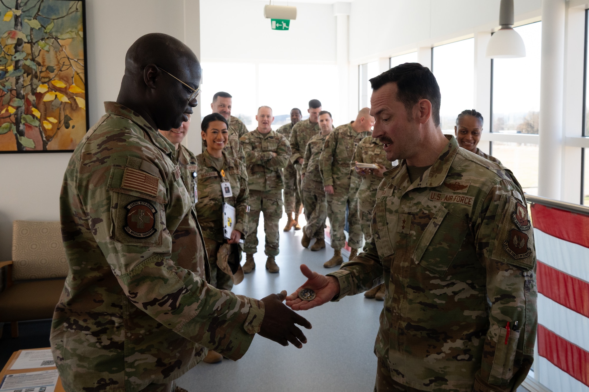 U.S. Air Force Maj. Gen. Paul Moga, Third Air Force commander, coins Staff Sgt. Koumboguidja Kantchilbe