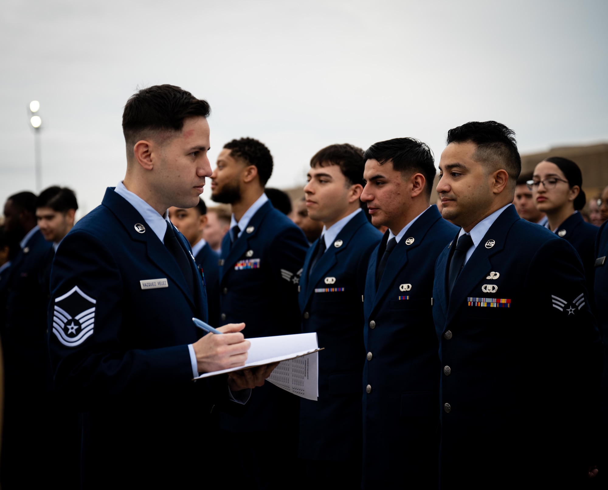 U.S. Air Force Master Sgt. David Vazquez Velez, 47th Aircrew Flight Equipment, lead trainer, inspects Airmens’ blues at Laughlin Air Force Base on March 28, 2025. 1,200 total force Airmen lined up on the flightline for their standards and readiness review blues inspection. (U.S. Air Force photo by Airman 1st Class Harrison Sullivan)
