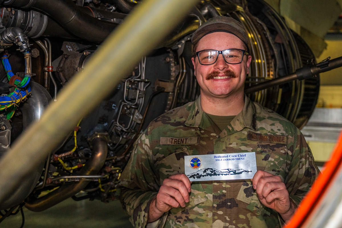 U.S. Air Force Airman Staff Sgt. Jarrod Trent, 62d Aircraft Maintenance Squadron dedicated crew chief, holds his DCC plaque while standing in the core section of a C-17 Globemaster III engine the Joint Base Lewis-McChord, Washington, March 26, 2025.