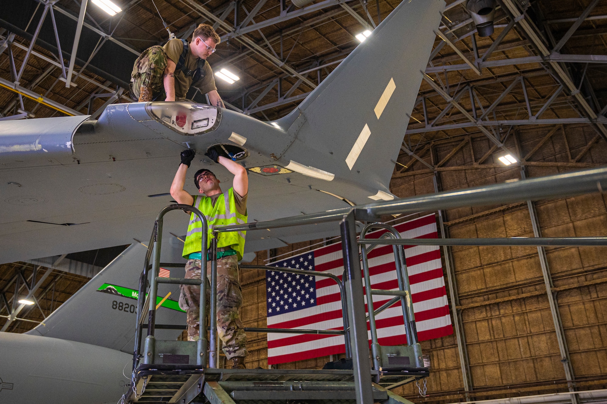 U.S. Air Force Airman First Class Jacob Eakle, top, and Senior Airman George Gonzales, both 62d Aircraft Maintenance Squadron assistant dedicated crew chiefs, work to remove the wing tip assembly on a C-17 Globemaster III at Joint Base Lewis-McChord, Washington, March 26, 2025.