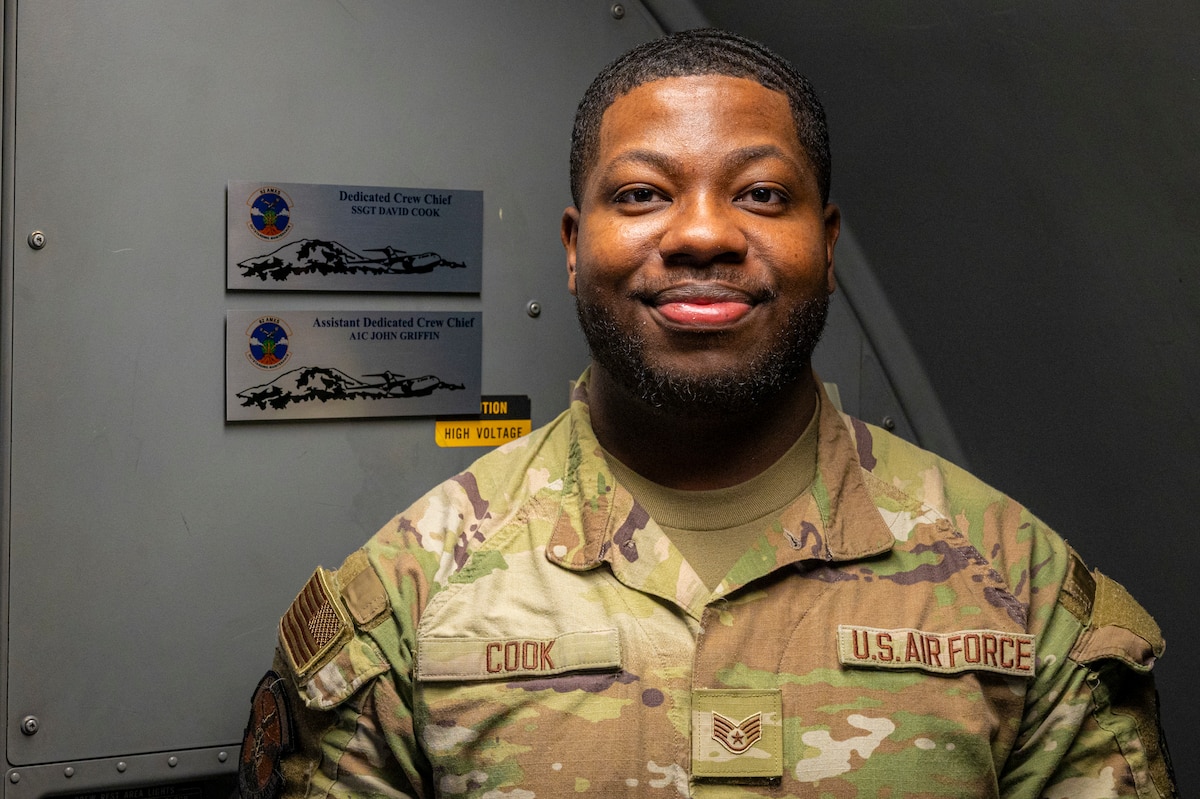 U.S. Air Force Senior Airman David Cook, 62d Aircraft Maintenance Squadron dedicated crew chief, stands next to the plaque marking one of the two C-17 Globemaster IIIs, tail 0103, he takes ownership of at Joint Base Lewis-McChord, Washington, March 26, 2025.