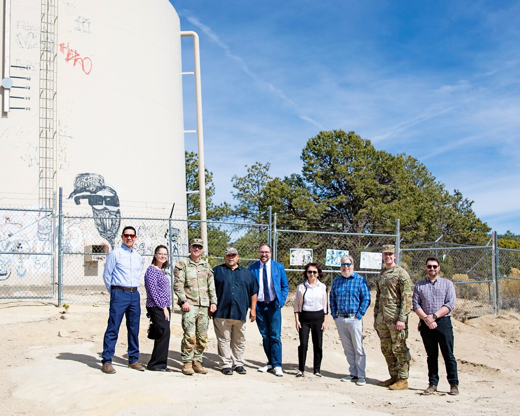 (l-r): Brian Sanchez, Section 595 program manager, Albuquerque District; Khrystina Campana, chief, Resource Management Office, Albuquerque District; Lt. Col. Matthew Miller, commander, USACE-Albuquerque District; Denny Herrera, mayor, Village of Cuba, N.M.; Jacob Pauley, deputy district engineer, Albuquerque District; Jeanette Linville, consultant with the Village of Cuba; Jared Minor, chief, Civil Works, Albuquerque District; 1st Lt. Garrett Falk, project manager, Albuquerque District; and Andrew Petersen, assistant project manager, Albuquerque District, visit the site of the existing water tank after the signing of the project partnership agreement between the Albuquerque District and the Village of Cuba, March 24, 2025. The existing water tank is seen behind the group. In phase two of the project this tank will be demolished, and a new 450,000-gallon water storage tank will be constructed.