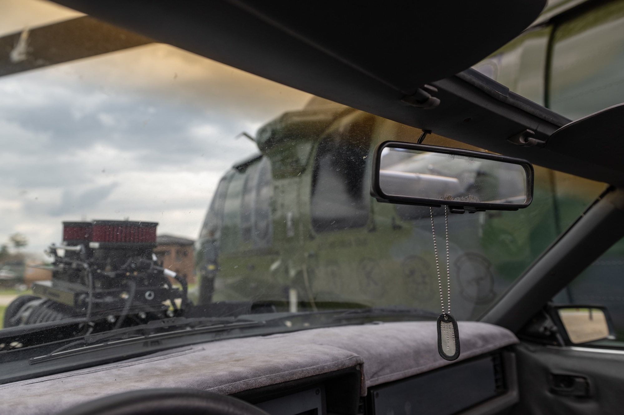 Dog tags hand on a mirror in a Mustang.