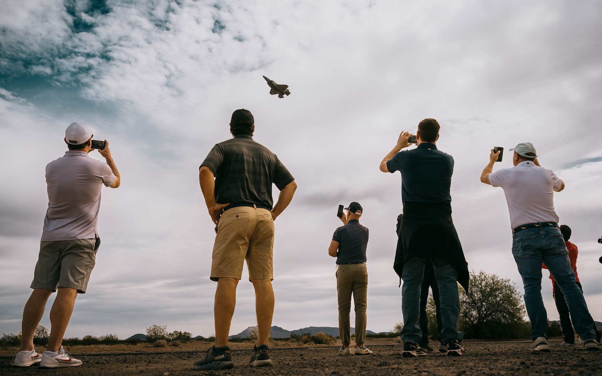 Community leaders watch a U.S. Air Force F-35A Lightning II assigned to the 56th Fighter Wing perform evasive maneuvers.