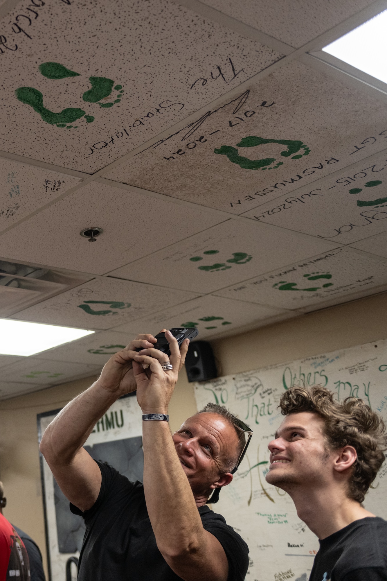 A man takes a picture on a phone.
