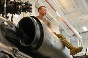 Soldier sits on top of an aircraft.