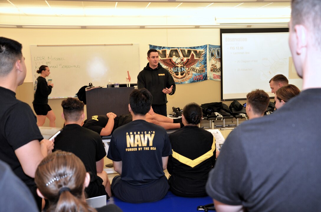 Lt. Cmdr. Patrick Mitchell, Medical Education and Training Campus Physical Therapy Technician course director, addresses students during a demonstration of proper therapeutic exercise technique.