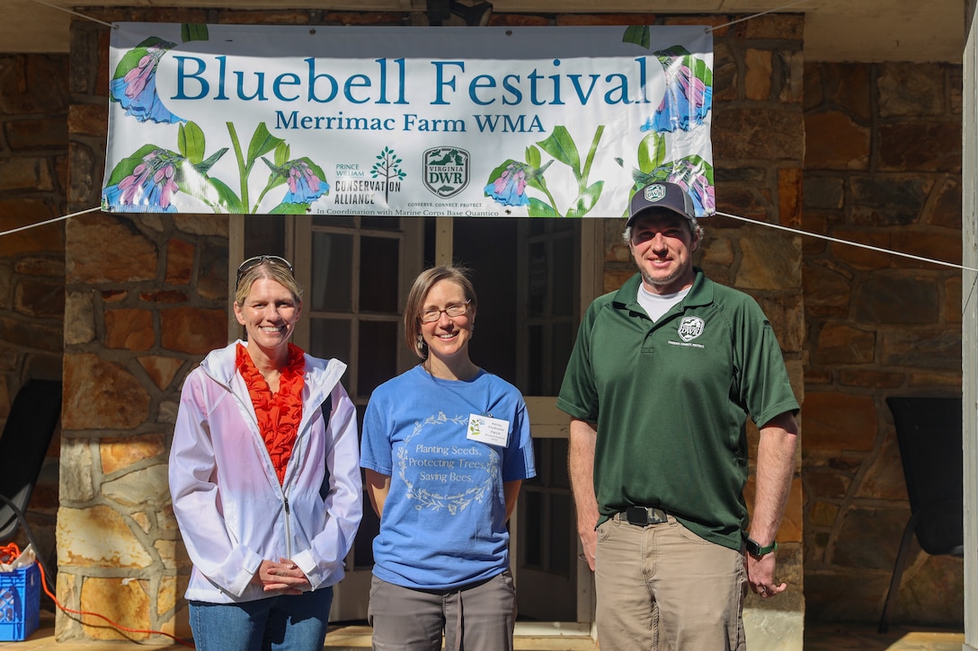 From the left U.S. Marine Corps Col. Jenny Colegate, the commanding officer of Marine Corps Base Quantico, Ashley Studholme, the executive director of the Prince William Conservation Alliance, and Tom Gordy, supervisor of the Brentsville District, pose for a photo at the annual Bluebell Festival at Merrimac Farm, Nokesville, Virginia, March 30, 2025. The Bluebell Festival began in 2008 after MCB Quantico partnered with Prince William Conservation Alliance, the Virginia Department of Game and Inland Fisheries, and the Virginia Department of Conservation and Recreation to preserve the land and habitat for conservation purposes. The farm has over 300 acres of wetlands and vernal pools, which is one of the most threatened habitats in the United States and creates the perfect area for thousands of bluebell flowers to grow and flourish. (U.S. Marine Corps photo by Sgt. Miranda C. DeKorte)