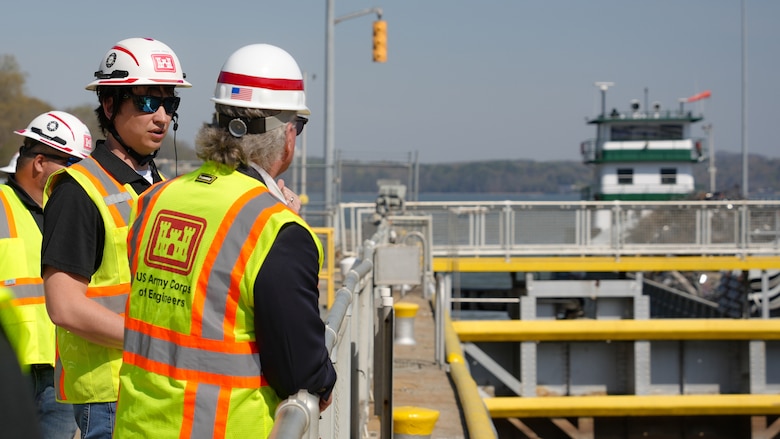 Chase Green, lock operator with the U.S. Army Corps of Engineers Nashville District, discusses current Chickamauga Lock operations with Rep. Mike Collins, Georgia 10th District, chairman of the House Subcommittee on Water Resources and Environment, at the Chickamauga Lock Replacement Project in Chattanooga, Tennessee, March 28, 2025. The current lock has experienced an alkali-aggregate reaction causing its aging concrete to expand and crack. The new lock will be able to accommodate nine barges per lockage. (USACE Photo by Jeremy Croft)