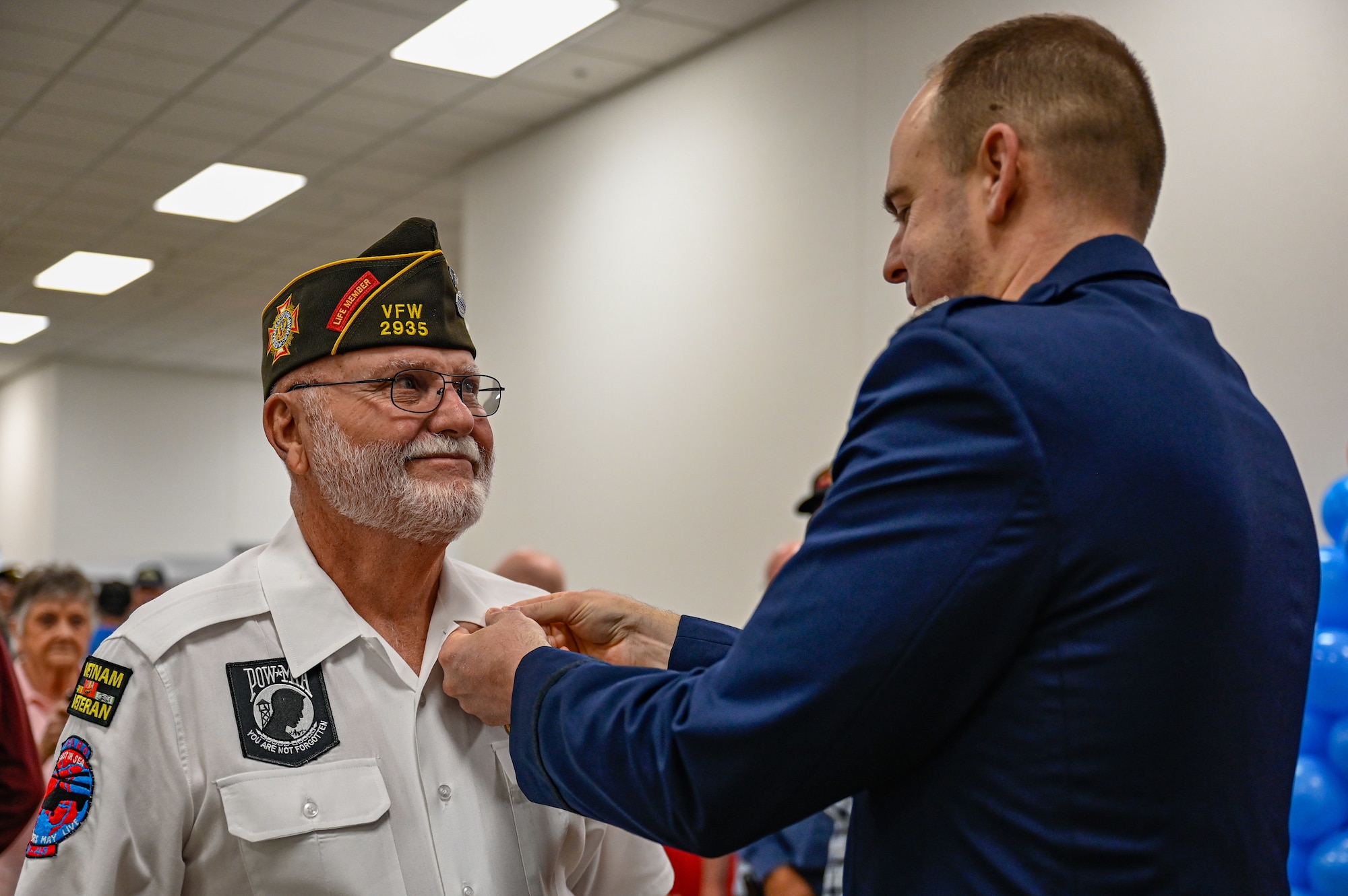 A Vietnam War veteran receives a commemorative lapel pin from base leadership during a ceremony at Little Rock Air Force Base, Arkansas, March 29, 2025. The Army and Air Force Exchange Service partnered with The United States of America Vietnam War Commemoration to present free commemorative lapel pins to veterans who served on active duty in the U.S. Armed Forces from Nov. 1, 1955, to May 15, 1975 – regardless of location.