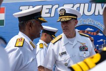 VISAKHAPATNAM, Andhra Pradesh, India (April 1, 2025) - Rear Adm. Greg Newkirk, Commander, Task Force (CTF) 70, speaks with Indian Navy (IN) Rear Adm. Susheel Menon, Flag Officer Commanding Eastern Fleet (FOCEF), on the flight deck aboard the IN amphibious transport dock INS Jalashwa (L41) during the opening ceremony of Exercise Tiger Triumph 2025, at the Naval Dockyard, Visakhapatnam, Andhra Pradesh, India, April 1. Tiger Triumph is a joint and combined U.S.-India exercise focused on humanitarian assistance and disaster relief readiness and interoperability. Tiger Triumph enables U.S. and Indian armed forces to improve interoperability and bilateral, joint, and service readiness in the Indian Ocean region and beyond to support a free and open Indo-Pacific. (U.S. Navy photo by Mass Communication Specialist 1st Class Caroline H. Lui)